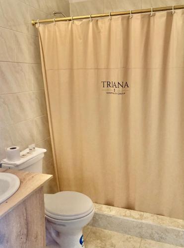 a bathroom with a toilet and a shower curtain at Hostería El Troje Experience in Riobamba