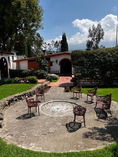 a group of chairs sitting on a stone patio at Hostería El Troje Experience in Riobamba
