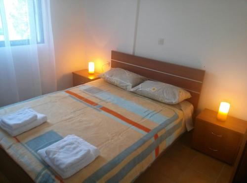 a bedroom with a bed with two lamps on it at Erofili in Pefkochori