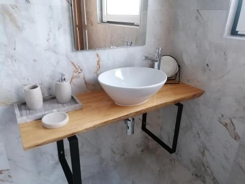 a bathroom with a white sink and a mirror at Casa D'Avó Bina Alojamento Local in Viana do Castelo