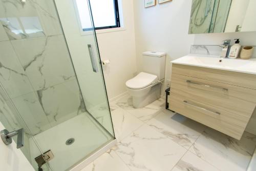 a bathroom with a shower and a toilet and a sink at Tranquil 2 bed townhouse w/carparking in Christchurch