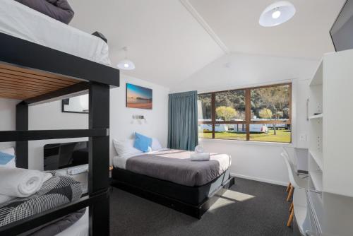 a bedroom with two bunk beds and a window at Kaiteriteri Reserve Cabins in Kaiteriteri