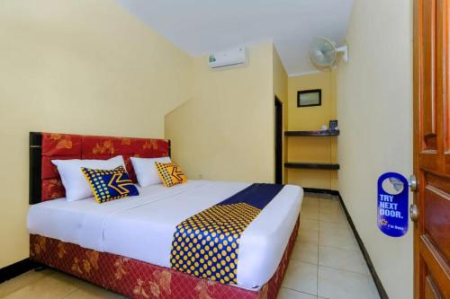 a bedroom with a large bed with colorful pillows at The Ellen Hotel by ecommerceloka in Senggigi 
