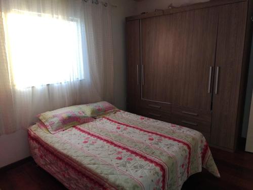 1 dormitorio con 1 cama, vestidor y ventana en All- Suítes Praia Arraial -FIGUEIRA, en Arraial do Cabo