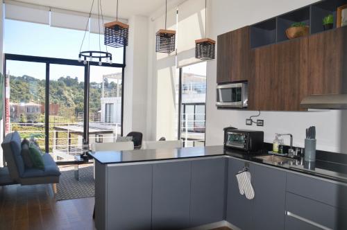 a kitchen with a counter with a microwave at Cozy Stays Cayala Apartments 602 in Guatemala