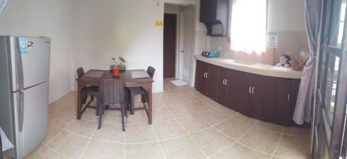 a small kitchen with a table and a refrigerator at Tresha Lance Apartelle in Boracay