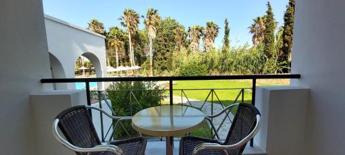 a table and chairs on a balcony with a view at Andromeda Hotel Apartments in Kos Town
