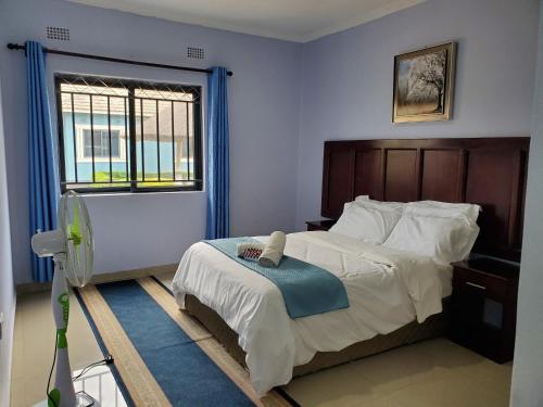 a bedroom with a large bed and a window at Sweet Retreat in Lusaka
