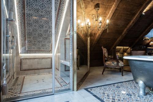 a bathroom with a tub and a chandelier at Atrium Konak in Novi Sad