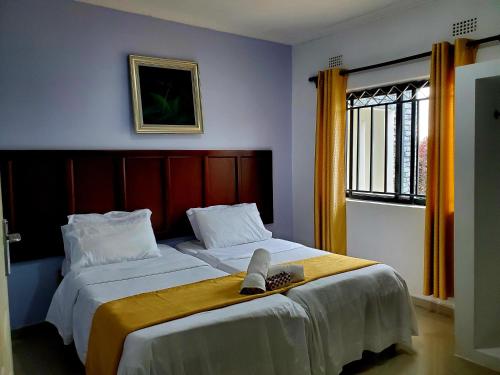 a bedroom with two beds and a window at Sweet Retreat in Lusaka