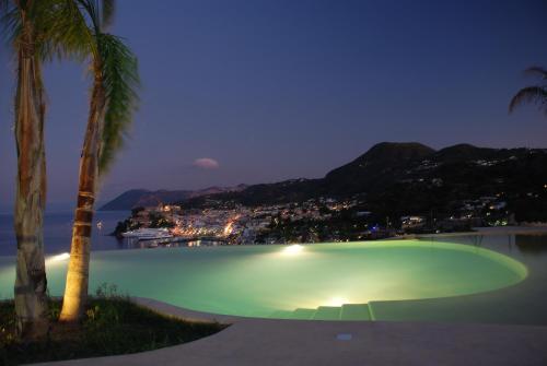 a large green pool with a tennis court at night at Hotel Villa Enrica - Aeolian Charme in Lipari