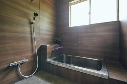 a bathroom with a sink and a window at MtFuji Guest House Kikkake in Fujiyoshida