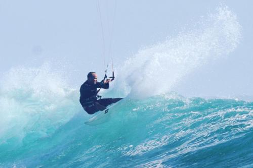 Un uomo che cavalca un'onda su una tavola da surf nell'oceano di Arista Lakey Peak House a Huu