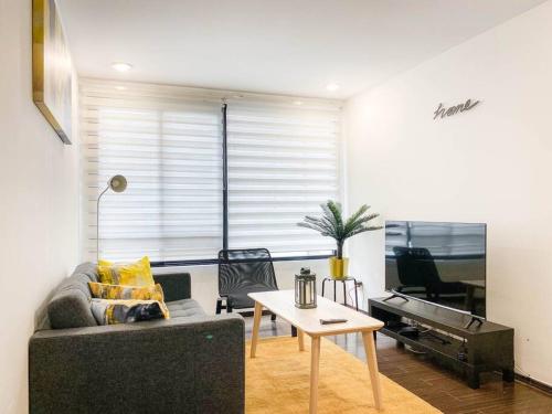 a living room with a couch and a table and a piano at Departamento en la Condesa Roma Ciudad de México in Mexico City