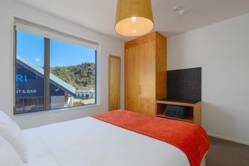 1 dormitorio con cama y ventana grande en Kaiteriteri Reserve Apartments en Kaiteriteri
