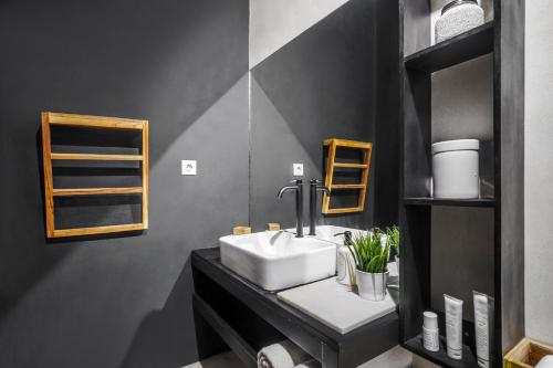 a bathroom with a sink and a black wall at Villa Lagoon - Elegant & Absolute BeachFront in Nusa Ceningan in Nusa Lembongan