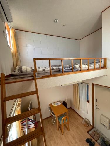 a room with two bunk beds and a table at 大宮溫馨小屋 in Saitama