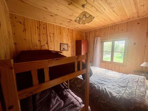 a bedroom with a bunk bed in a wooden cabin at Casa Azul in Potrerillos