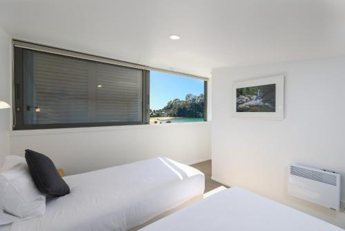 a bedroom with a bed and a large window at Kaiteriteri Reserve Apartments in Kaiteriteri