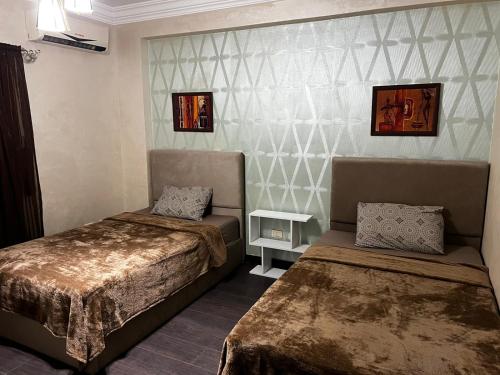 a hotel room with two beds and a table at Luxury Modern Appartment in New Cairo in Cairo