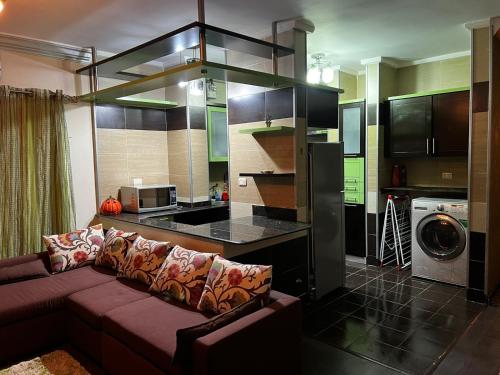 a living room with a couch and a kitchen at Luxury Modern Appartment in New Cairo in Cairo