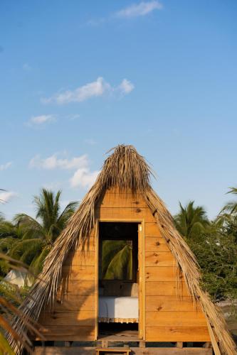 Cabaña con techo de paja y cama en Nattivo Ecoglamping en La Sabrosa
