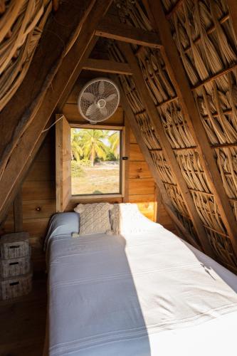 Cama en habitación con ventana en Nattivo Ecoglamping en La Sabrosa