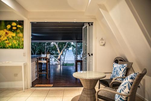 a living room with a table and a view of the ocean at Cottonwood Beachfront, Port Douglas in Oak Beach