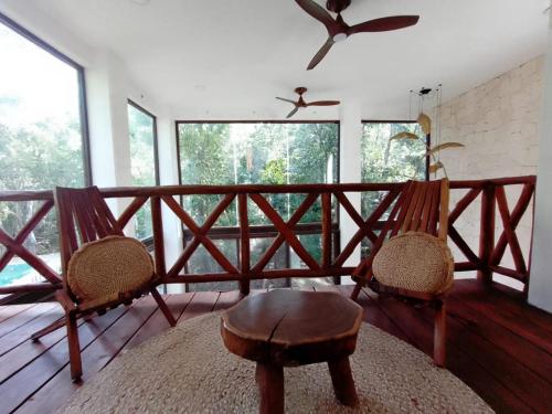 a room with two chairs and a table on a balcony at Saasil Kaax in Chemuyil