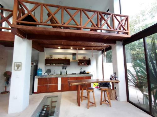 uma cozinha em plano aberto com uma mesa de madeira e uma grande janela em Saasil Kaax em Chemuyil