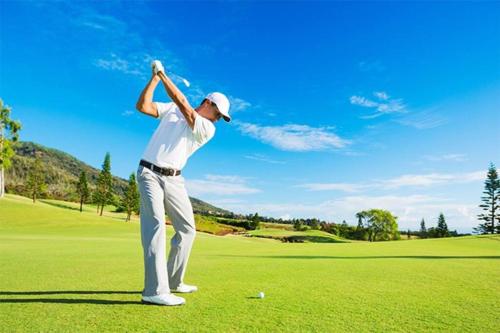 a man swinging a golf club on a golf course at 団体歓迎ジョイサウンドカラオケ付き北軽井沢超大型貸別荘7寝室5浴室20人泊まれる in Karuizawa