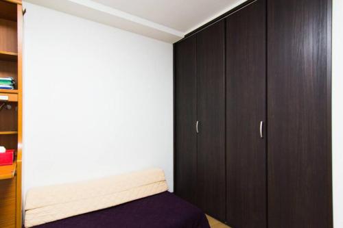 a bedroom with brown cabinets and a purple bed at Mochida's Guest House in Tokyo