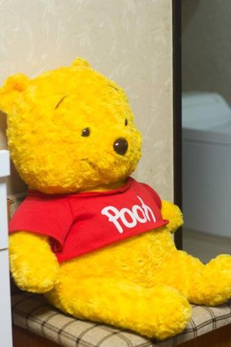 a yellow stuffed teddy bear sitting on a shelf at Mochida's Guest House in Tokyo
