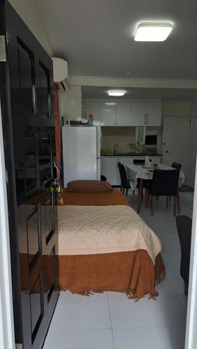 a bedroom with a bed and a kitchen with a refrigerator at Mead Road Homestay Tours & Transfers Studio in Suva