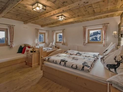 a bedroom with two beds and two windows at Large hut in the Pinzgau with a great view and its own sauna hut in Dorf