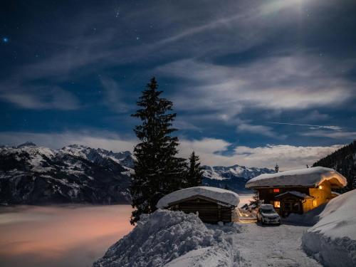 a snow covered cabin with a tree in the snow at Chalet in Hollersbach near Kitzbühel Ski Lift in Dorf