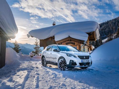a white car parked in the snow in front of a cabin at Chalet in Hollersbach near Kitzbühel Ski Lift in Dorf