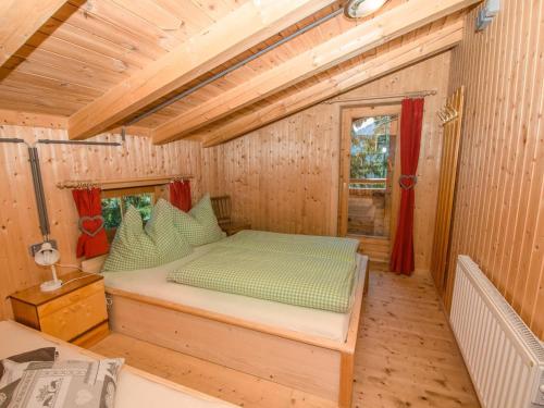 Cette chambre comprend un lit dans une cabane en bois. dans l'établissement Cozy hut in Pinzgau with Finnish sauna, à Dorf