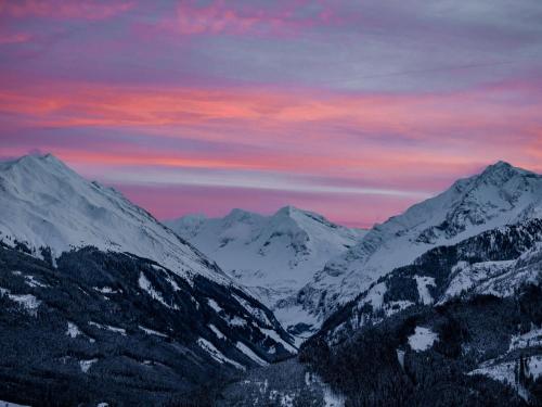 a group of snow covered mountains with a sunset at Chalet in Hollersbach near Kitzbühel Ski Lift in Dorf