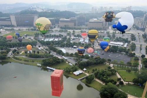 a group of hot air balloons flying over a city at The Icon2 Condo in IOI City Mall Putrajaya, Pool View in Putrajaya