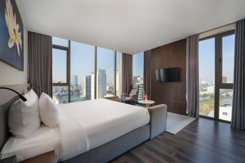 a bedroom with a large bed and a large window at Everland Hotel in Danang