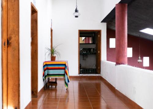 um corredor com uma cadeira com um cobertor colorido em Hostal Tribu Malinalco em Malinalco