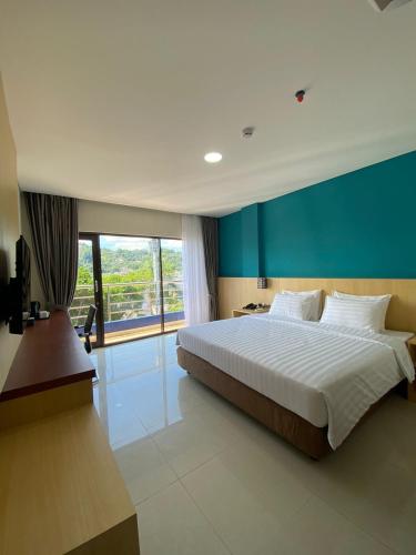 查亞普拉的住宿－Erbe Style Jayapura Papua By Horison，一间卧室设有一张大床和一个大窗户