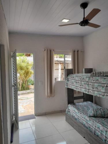 a room with bunk beds and a ceiling fan at Pousada do Forte in Praia Grande