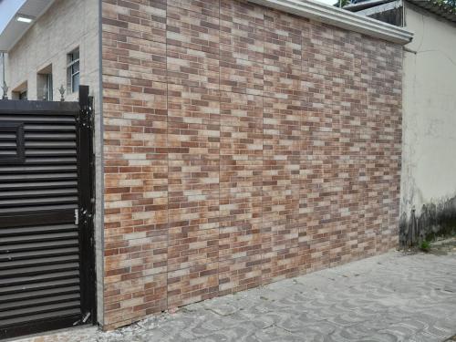 a brick wall with a gate and a door at Pousada do Forte in Praia Grande