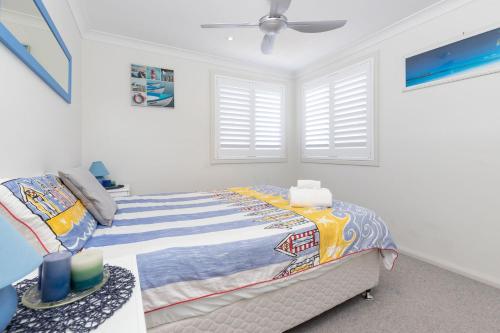 a bedroom with a bed and a ceiling fan at 3 of 29 Parkes St in Tuncurry
