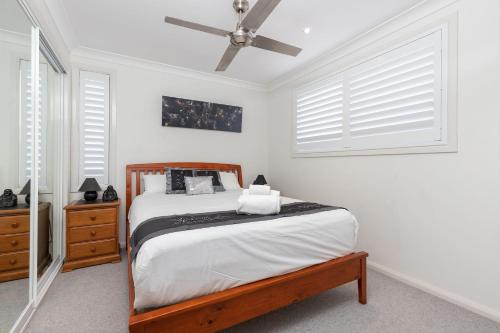 a bedroom with a bed and a ceiling fan at 3 of 29 Parkes St in Tuncurry