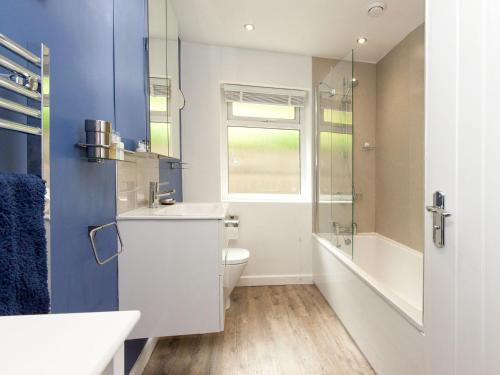 a bathroom with a sink and a toilet and a window at Rockmount 1 in Salcombe