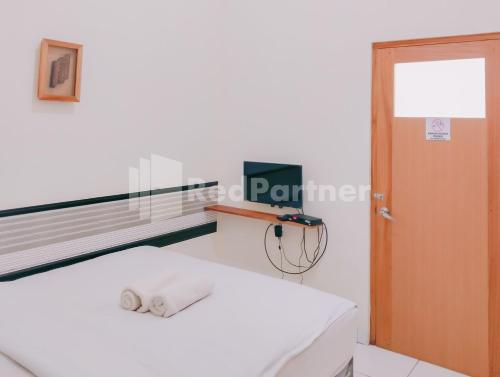 a living room with a white couch and a window at Siliwangi Guest House Syariah Tasikmalaya Mitra RedDoorz in Tasikmalaya