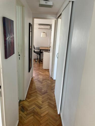 un pasillo con paredes blancas y suelo de madera en Habitación individual en departamento compartido, barrio Recoleta en Buenos Aires
